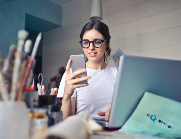 woman with glasses looking at phone