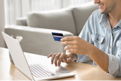 person on laptop holding debit card