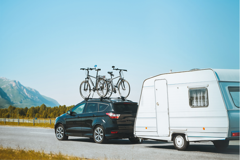 bikes on top of a car pulling a camper
