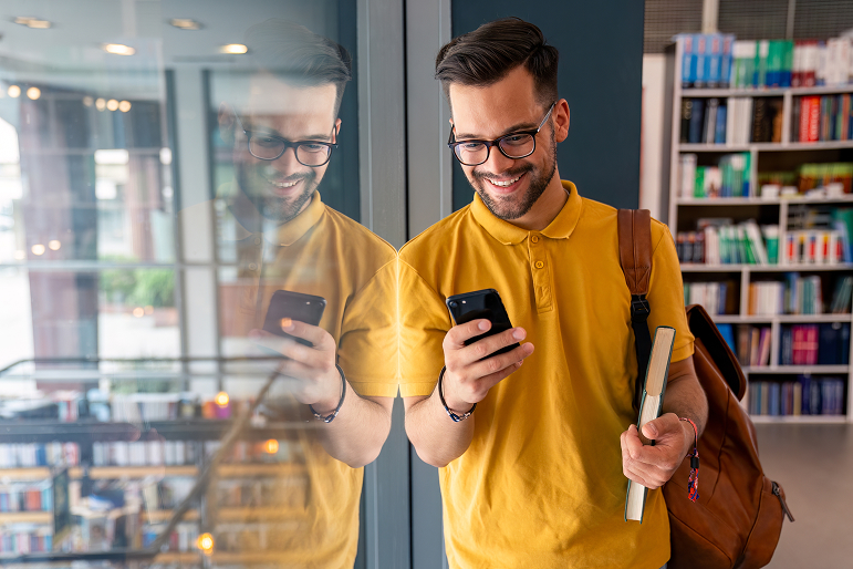 a man with a yellow shirt on his phone